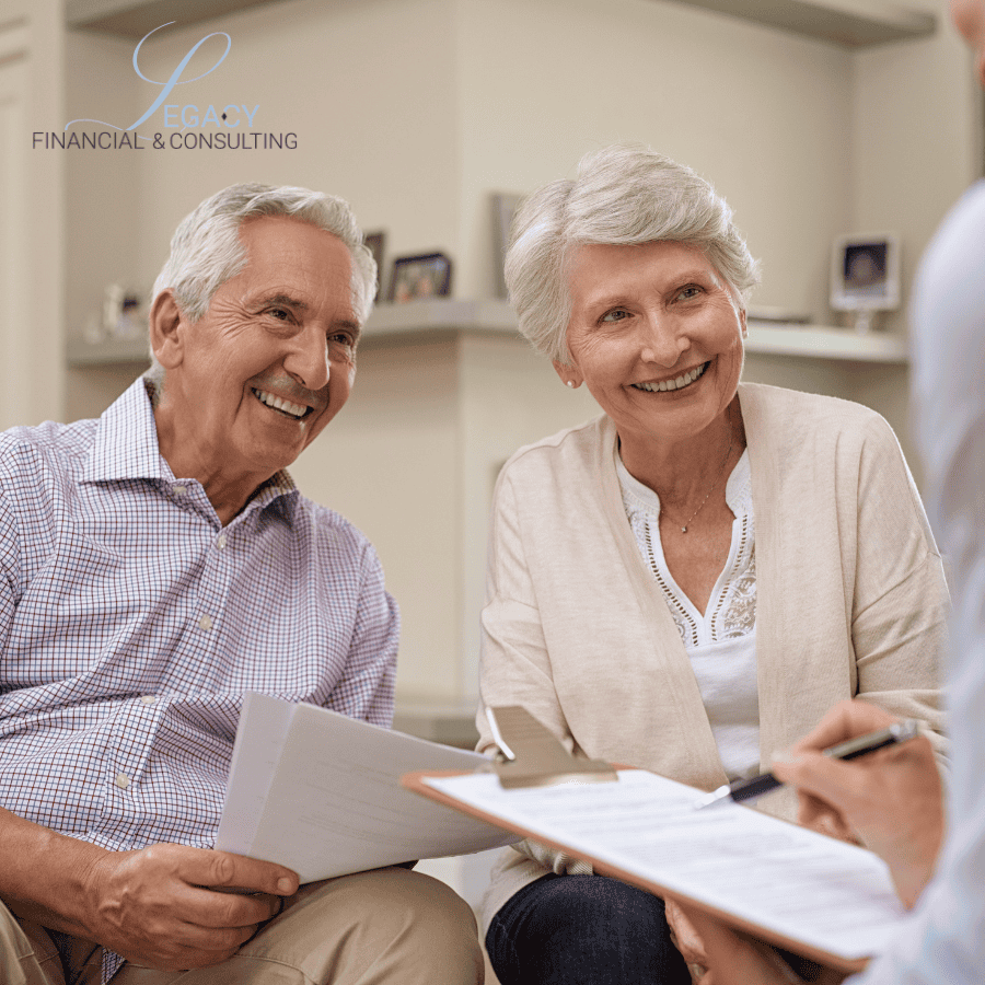 Senior couple smiling while reviewing financial documents with a consultant; clipboard and papers on their laps, Legacy Financial & Consulting logo in the upper left.