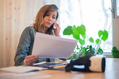 Woman on the phone reviewing an invoice while managing business cash flow